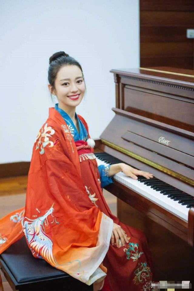 吉娜坐在钢琴前甜笑入镜,娇俏可人又美又可爱,真的有被她的汉服造型